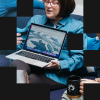 Woman holding a laptop and presenting to others