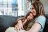 mom and daughter hugging on couch