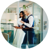 Two colleagues discuss documents in a modern office space.
